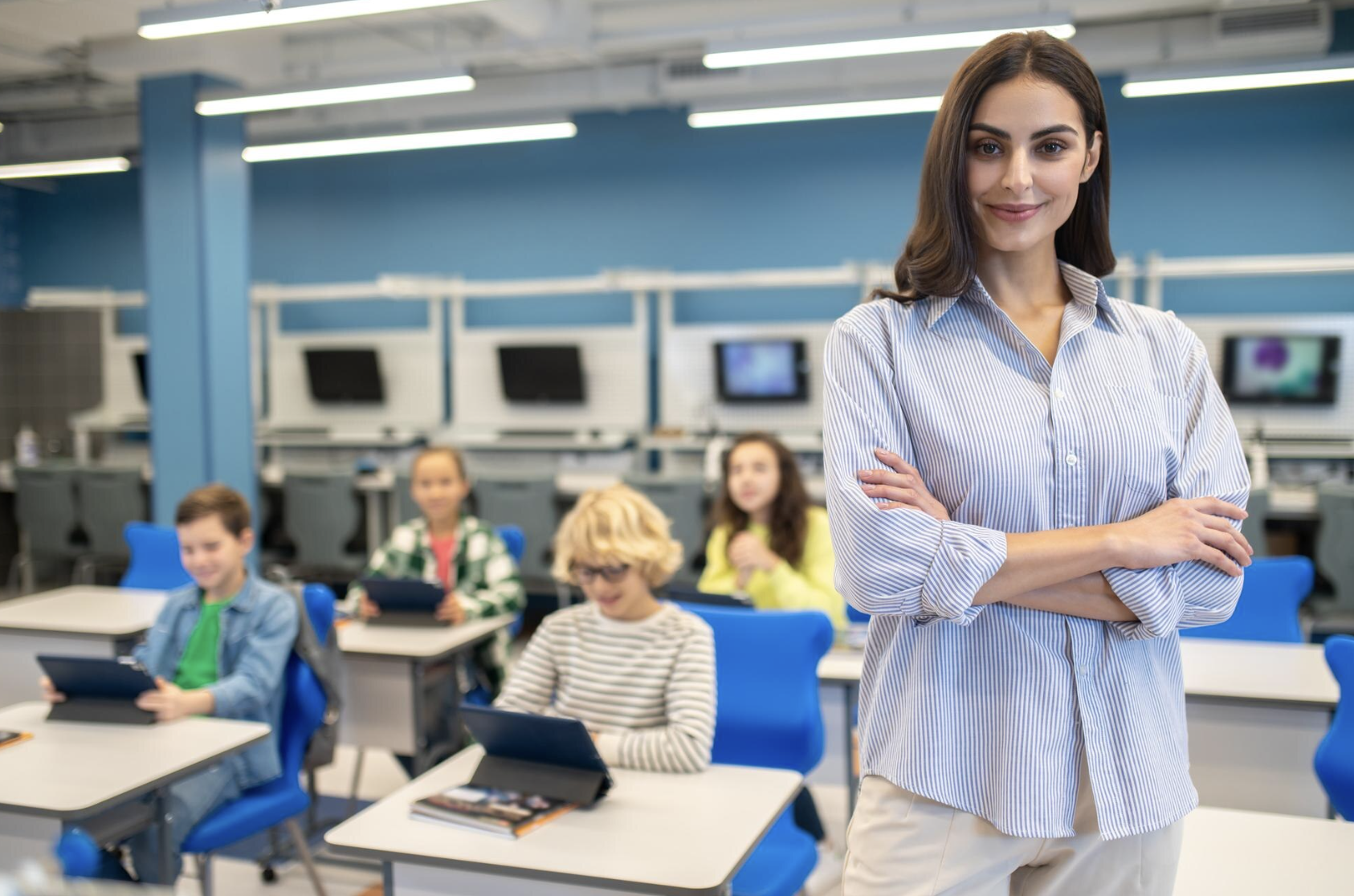 A teacher standing with students in a classroom